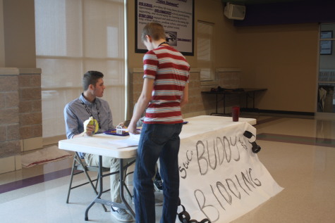 StuCo member Evan Fullerton runs the table as students bid on buddies.