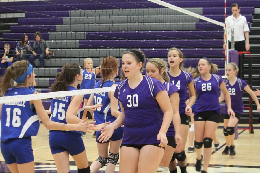 Middle School Volleyball team lines up to give opponents post-game high fives.