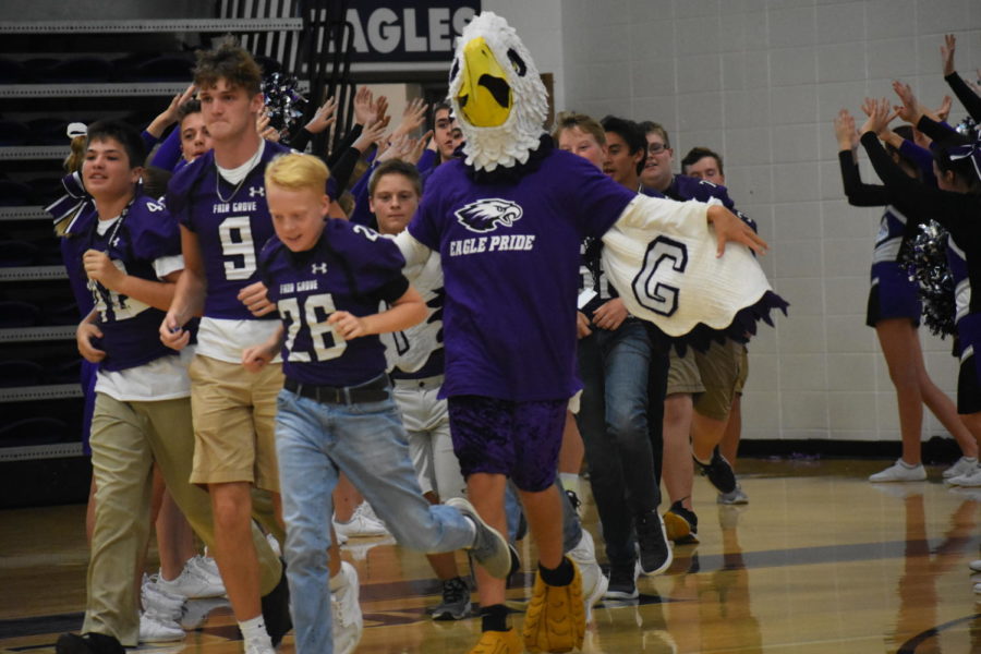 The Eagle runs out with members of the football team at the pep assembly