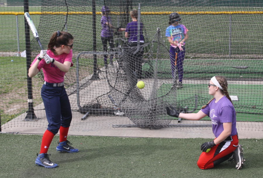 The MS Softball team practices in the batting cage.