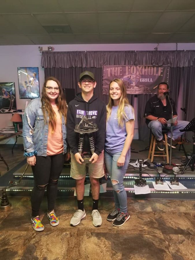 Seniors Taylor Brumage, Dylan Mooneyham, and Kelly Misemer pose with a trophy awarded at the car show.