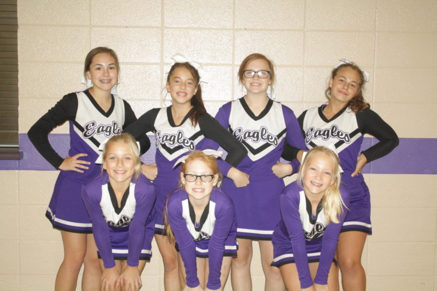 Middle school cheerleaders posing after a night of cheering