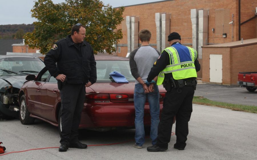 Former Fair Grove PD Officers Derek Zentner and Brian Way (from left to right) reenact a car crash scene in a presentation for Fair Grove students. 