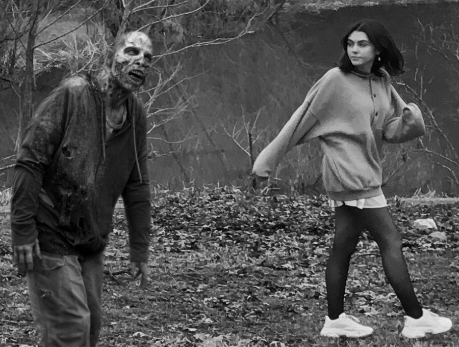 Katie Burch casually walking near a zombie.
