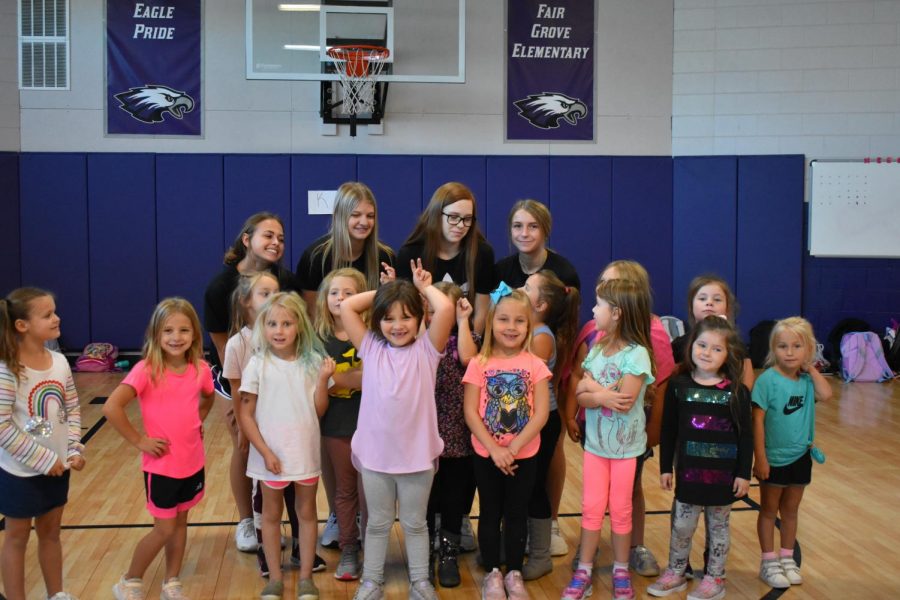 Kindergarten cheer girls with a few older cheerleaders.