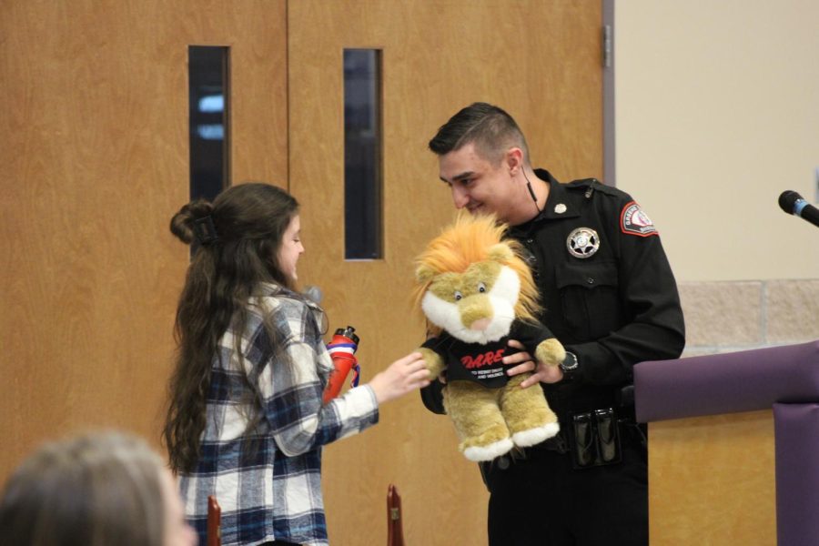 Officer Skyler Richardson giving the DARE essay contest grand prize to the winner, Olivia Broyles.