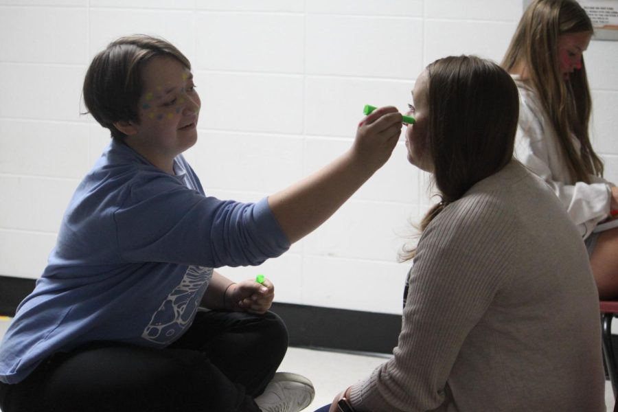 Nico Jenkins giving Mrs. Kisling a complimentary face painting. (Photo taken by Baily Carll)