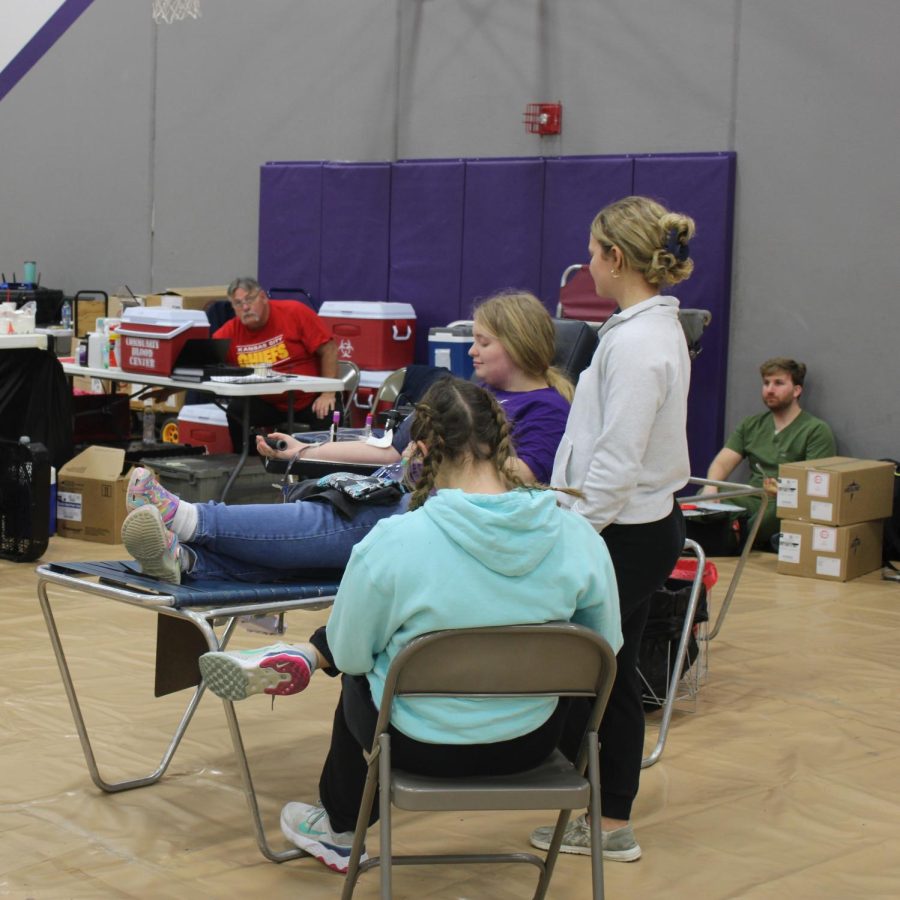NHS students Alyssa Snitker and Katie Mueller supporting Kailie Ankney while she gives blood at the Blood Drive. (photo taken by Brooklyn Williams)