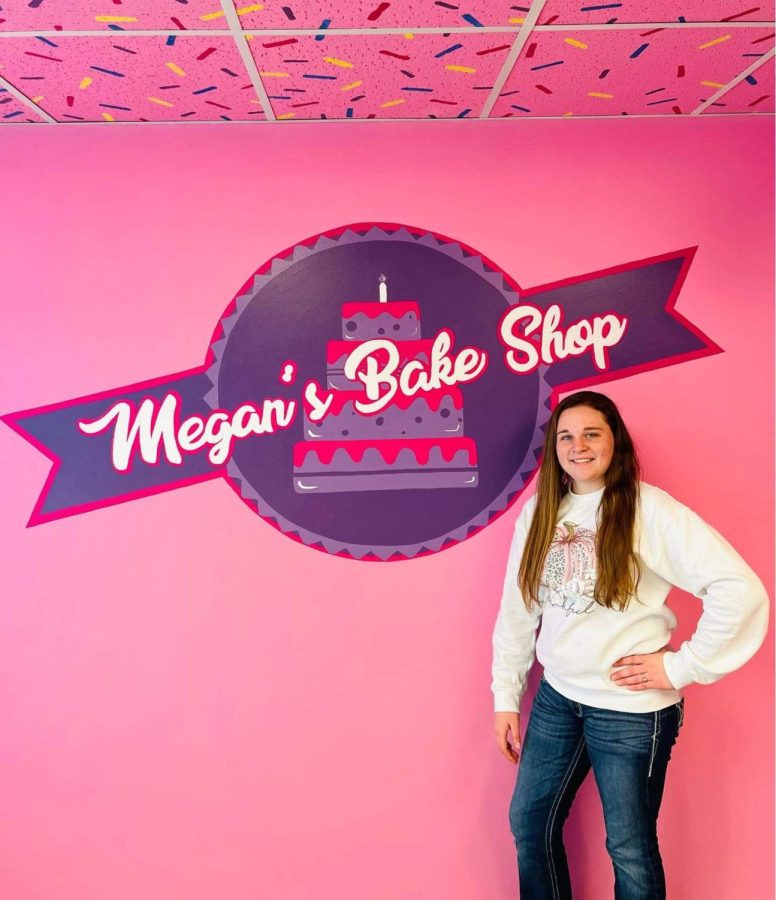 Megan standing in front of her in-store logo. (Photo provided by Megan Mecey)
