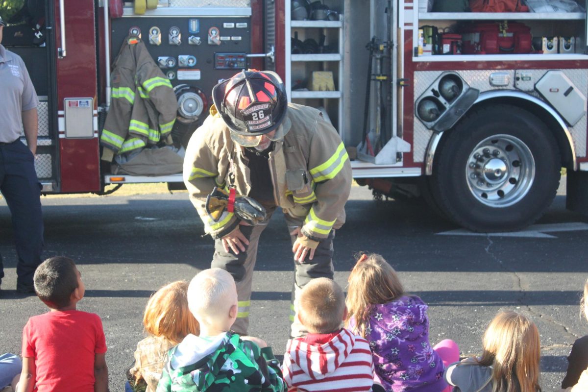 Fair Grove firefighter talking to first graders at the career day.