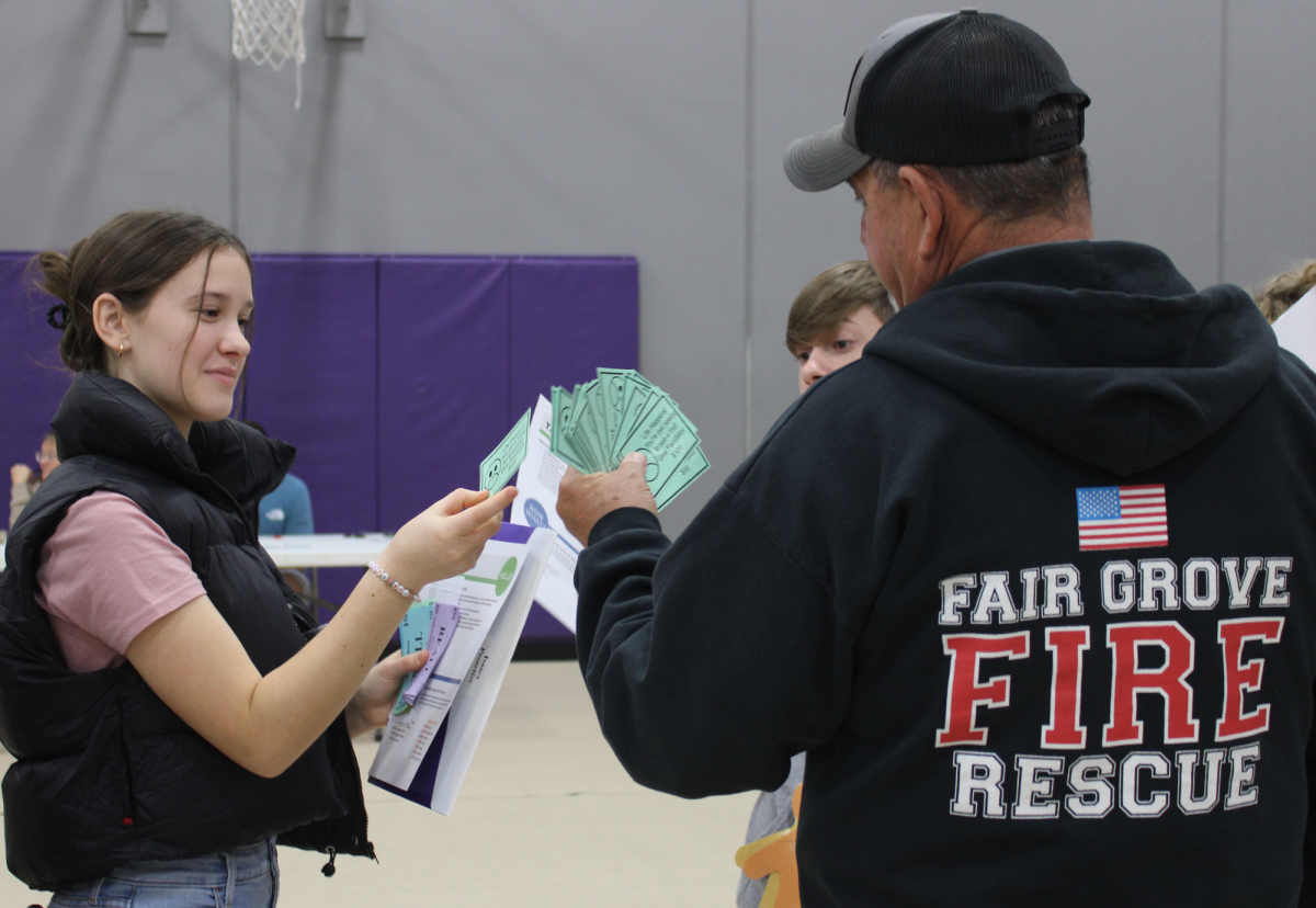 Firefighter Lt. Russel Milbauer fans out his cards of unfortunate life events to eight grader Lacie Workman.