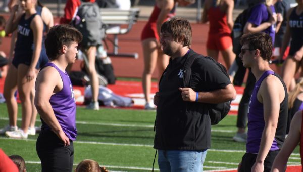 Coach Zanzie talking to track athletes Dylan George (10) and Liam Draper (12) at the Ozark Track Meet