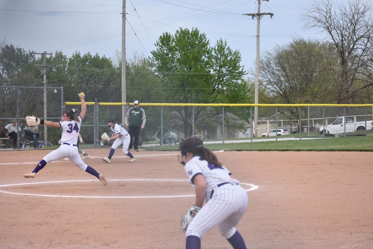 Aubrie+Voorhis+%289%29+pitching+while+her+twin+Addison+Voorhis+%289%29+plays+first+base