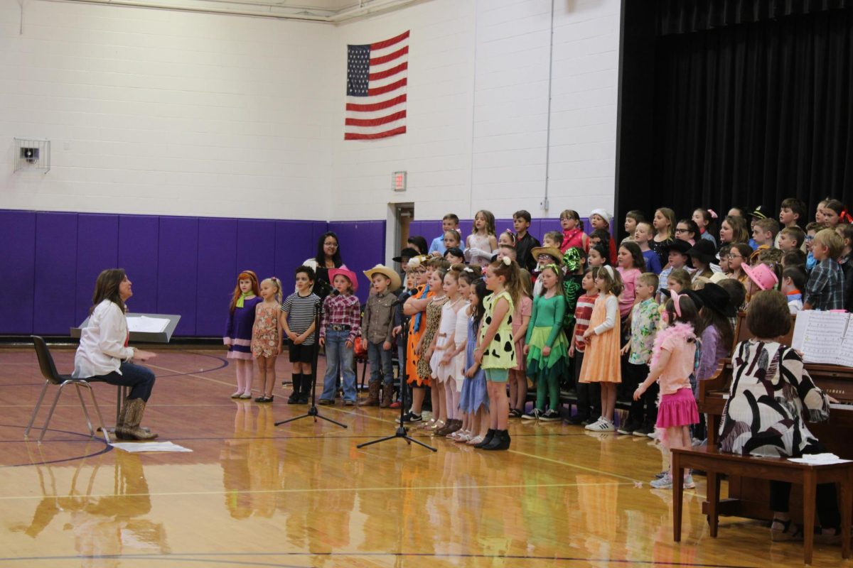 Mrs.+Lumley+leading+the+second+graders+in+performing+The+Flintstones+segment+of+the+program+on+3%2F21.
