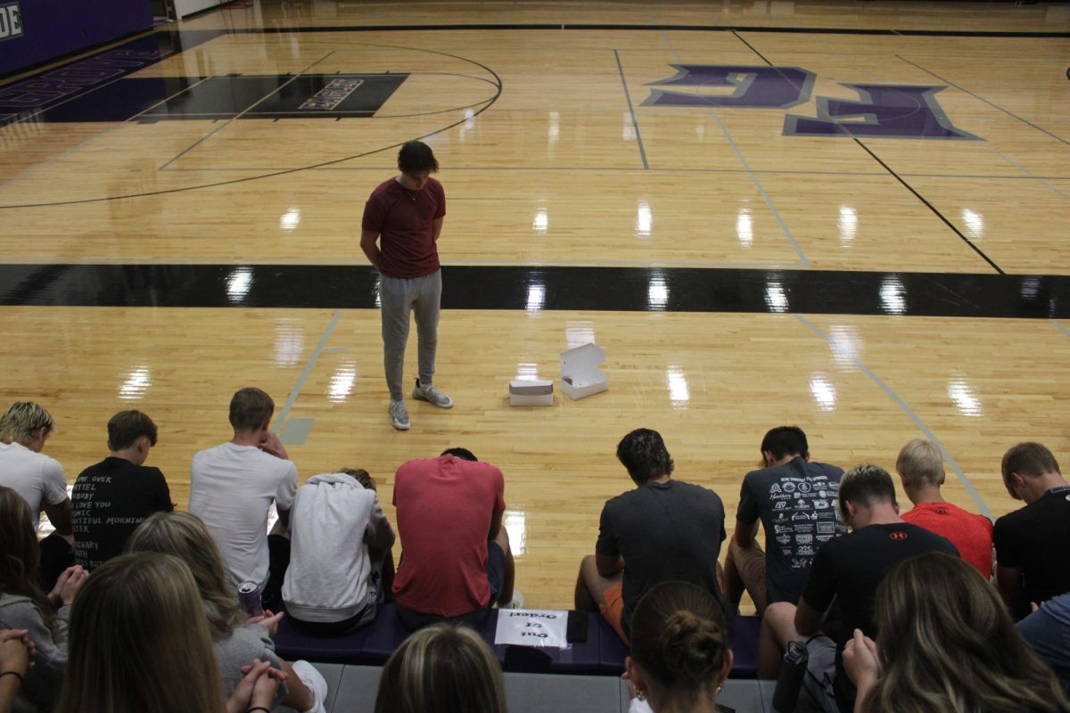 Jared Allen and the Fellowship of Christian Athletes bowing their heads in prayer.