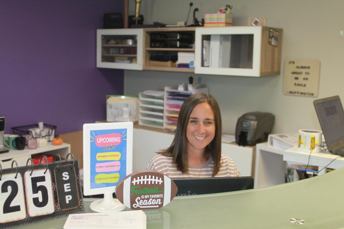 Fair Grove Elementary School Secretary, Holley Johnson, posing at her desk in the elementary office.