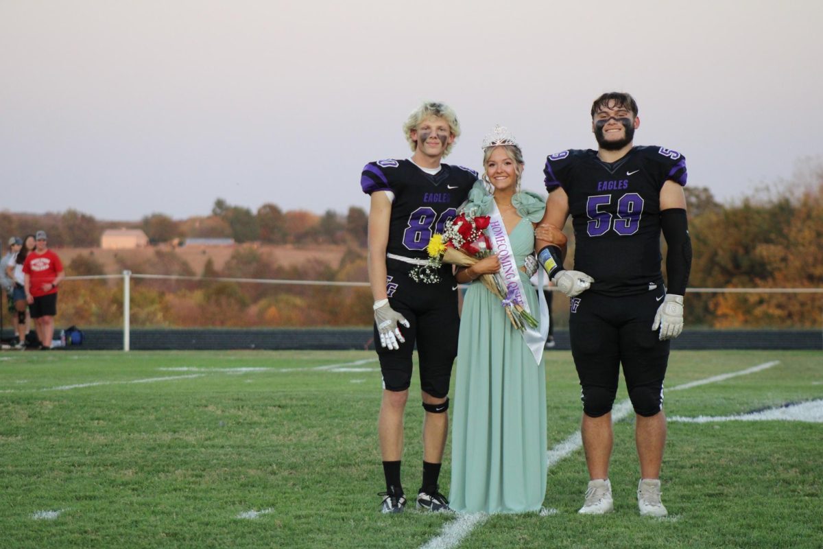 Senior Riley Frazier posing for pictures after being crowned Homecoming Queen.
On the left is Junior escort Gavin Brock and on the right is Senior escort Steven Lederich.