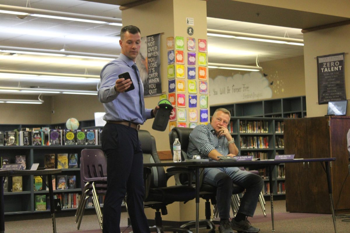 Dr. Christian Overstreet, Fair Grove High School Principal, demonstrating how phones will be put into a Yondr pouch. Overstreet then demonstrated how students would unlock their Yondr pouches.