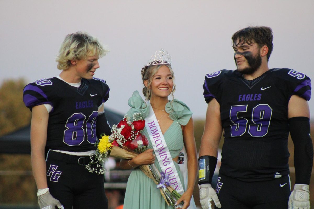 2024 Fair Grove Homecoming Queen and senior Riley Frazier on the football field after being crowned the homecoming queen on October 11th. On the left is junior escort Gavin Brock, and on the right is senior escort Steven Lederich