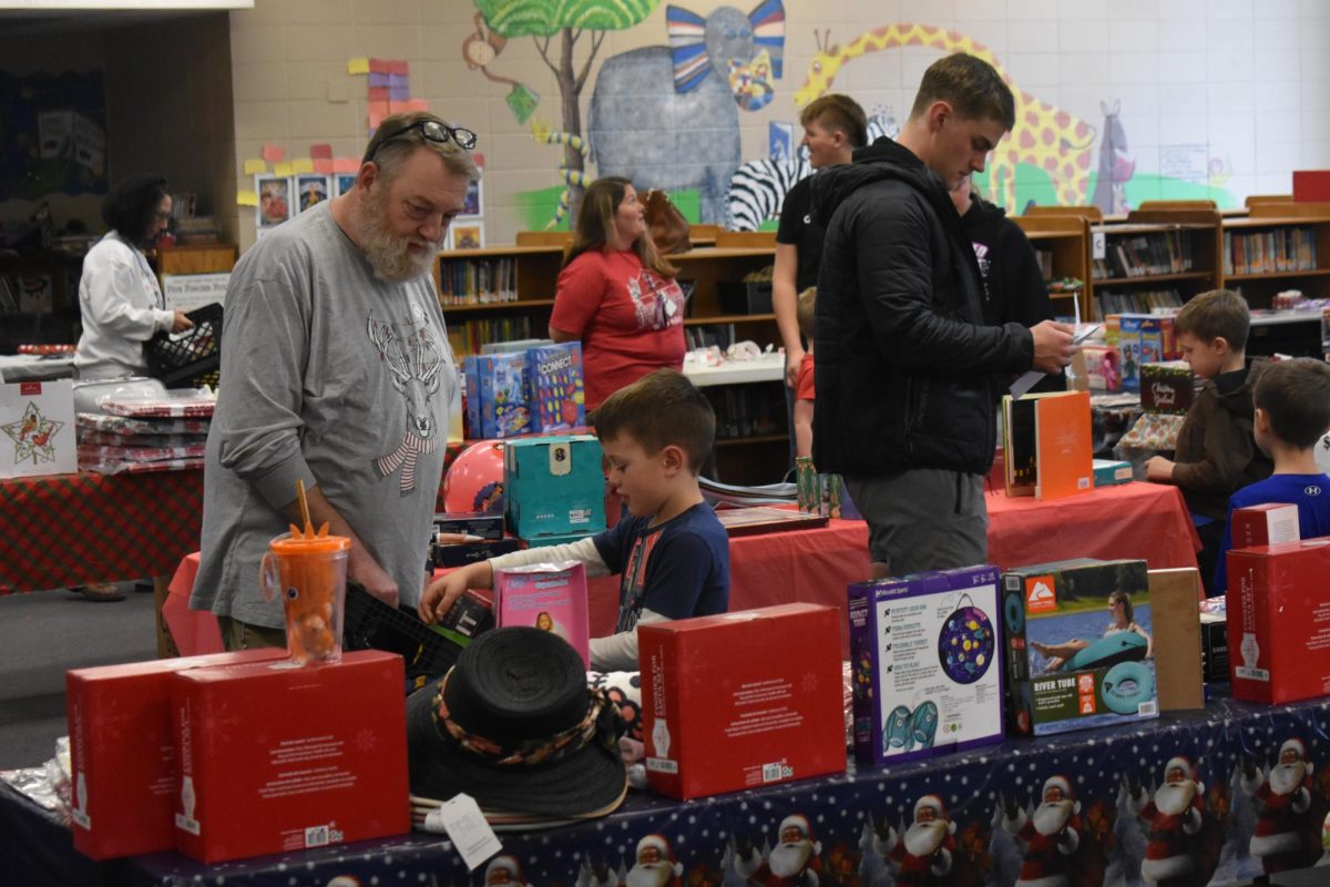 Elementary students choosing gifts for their family and friends at the PTO's Holiday Shop in Fair Grove Elementary School's library.