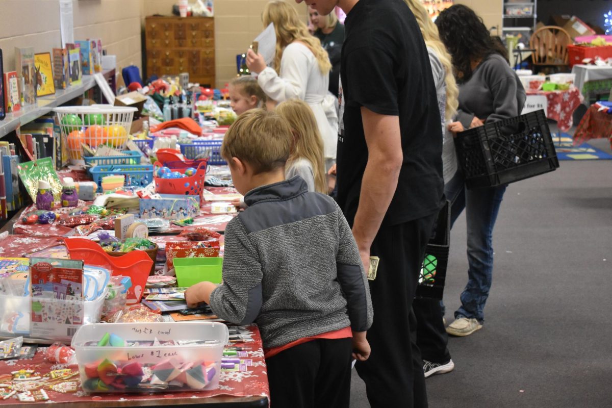 Elementary students choosing gifts for their family and friends at the PTO's Holiday Shop in Fair Grove Elementary School's library.