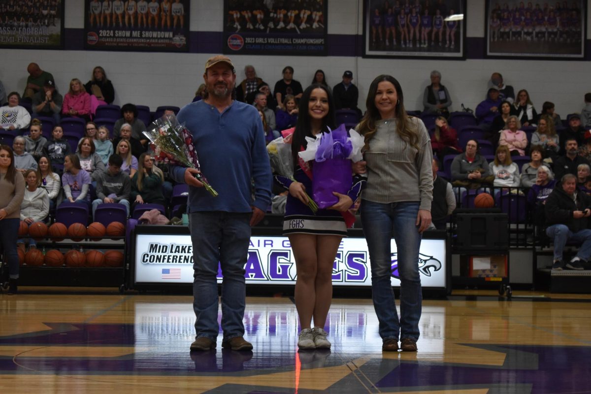 Brooklyn Mauldin (12) being escorted by Kip Lumley and Elizabeth Mauldin at the cheer and basketball senior night. 