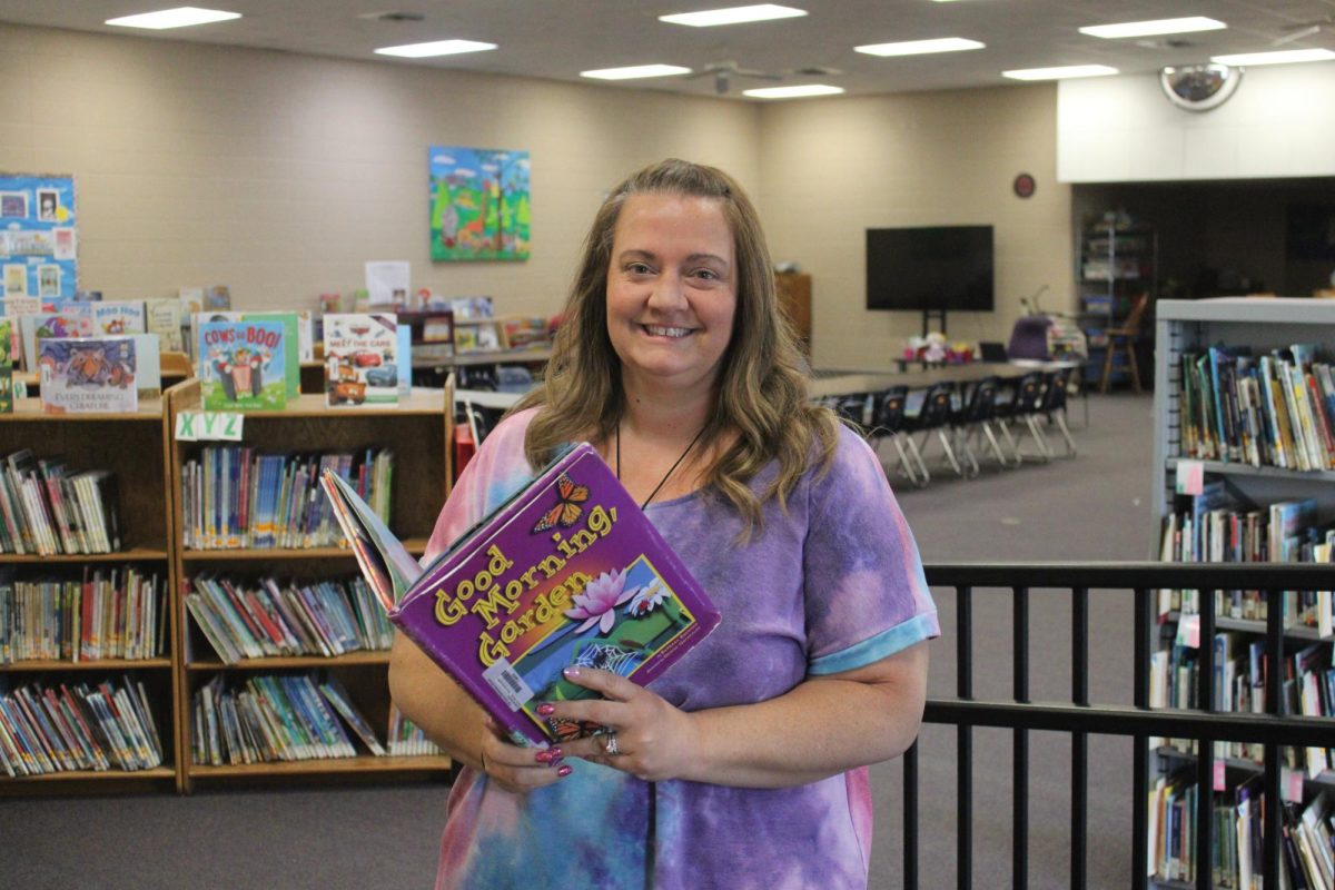 Mrs.Hampton, Fair Grove Elementary School Librarian, looking over book in the library.  