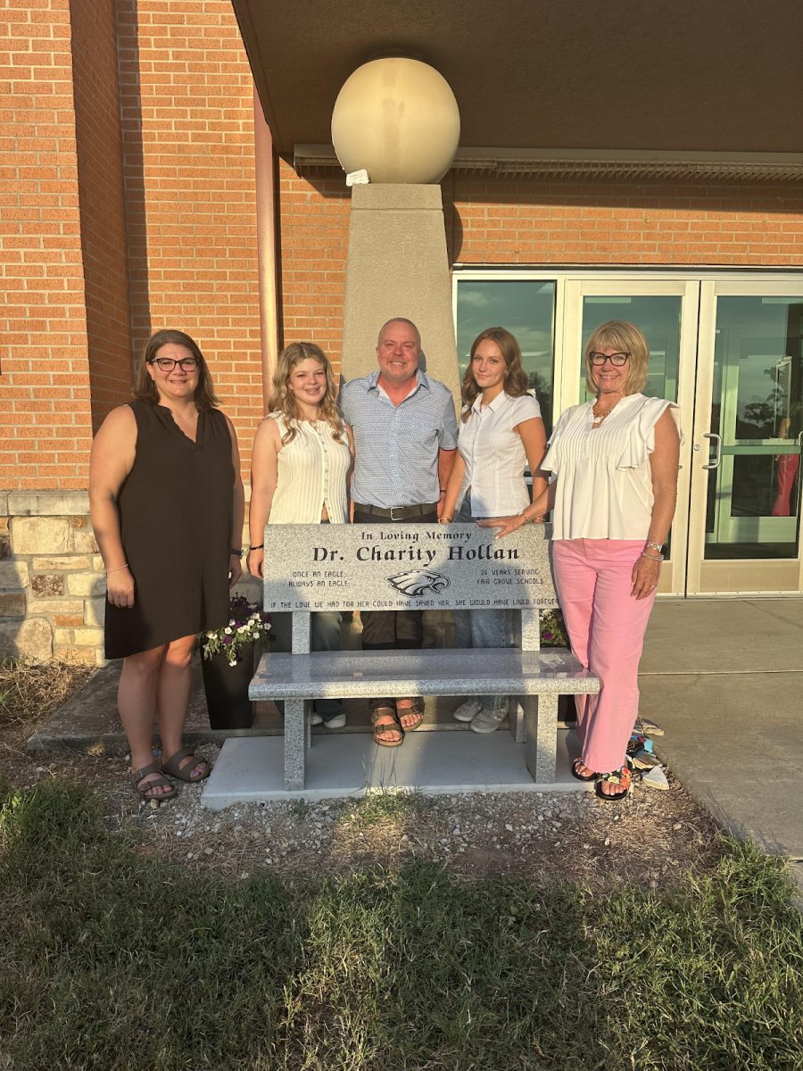 This is Charity Hollan's bench that sits in front of the Fair Grove elementary school. The bench sits in front of the elementary so that students and staff can honor and think about Dr. Hollan as they walk into the building.  The people in this picture from left to right are Brandee Lentz, Pearl Hollan, Chris Hollan, Claire Hollan, and Tammie Wilson.