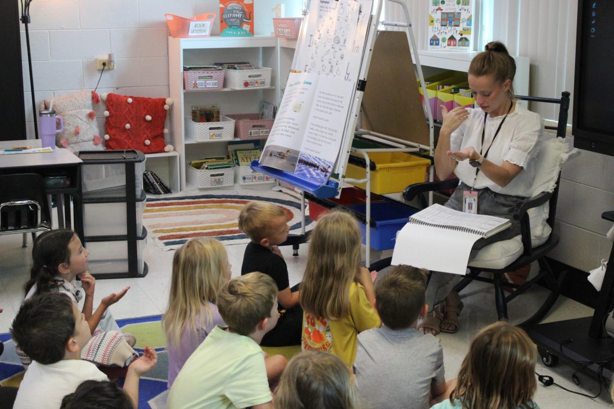 Leah Masters first grade class sitting around her ready to learn. Masters is sounding out the words to help them with reading. 
