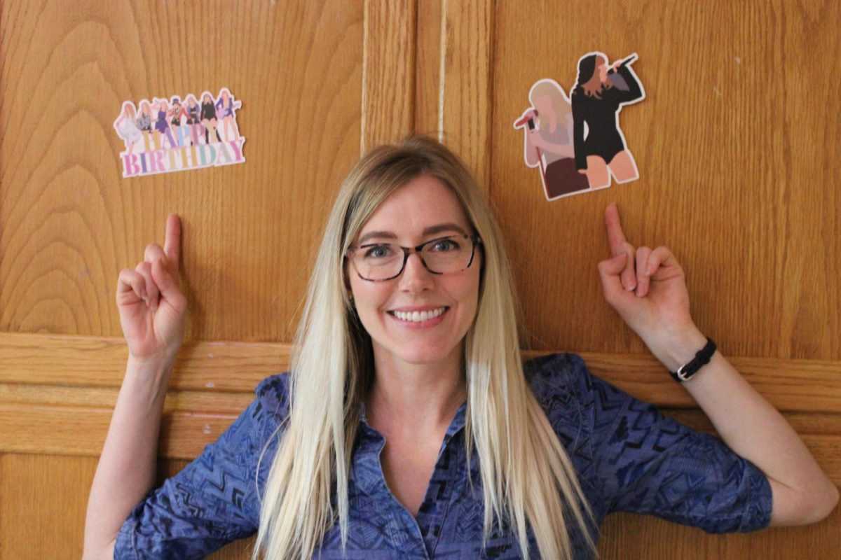 Spanish teacher Ms. Shelley Thornton pointing to a few of her many Taylor Swift decorations in her classroom. She is well-known as a "Swiftie" throughout Fair Grove High School.
