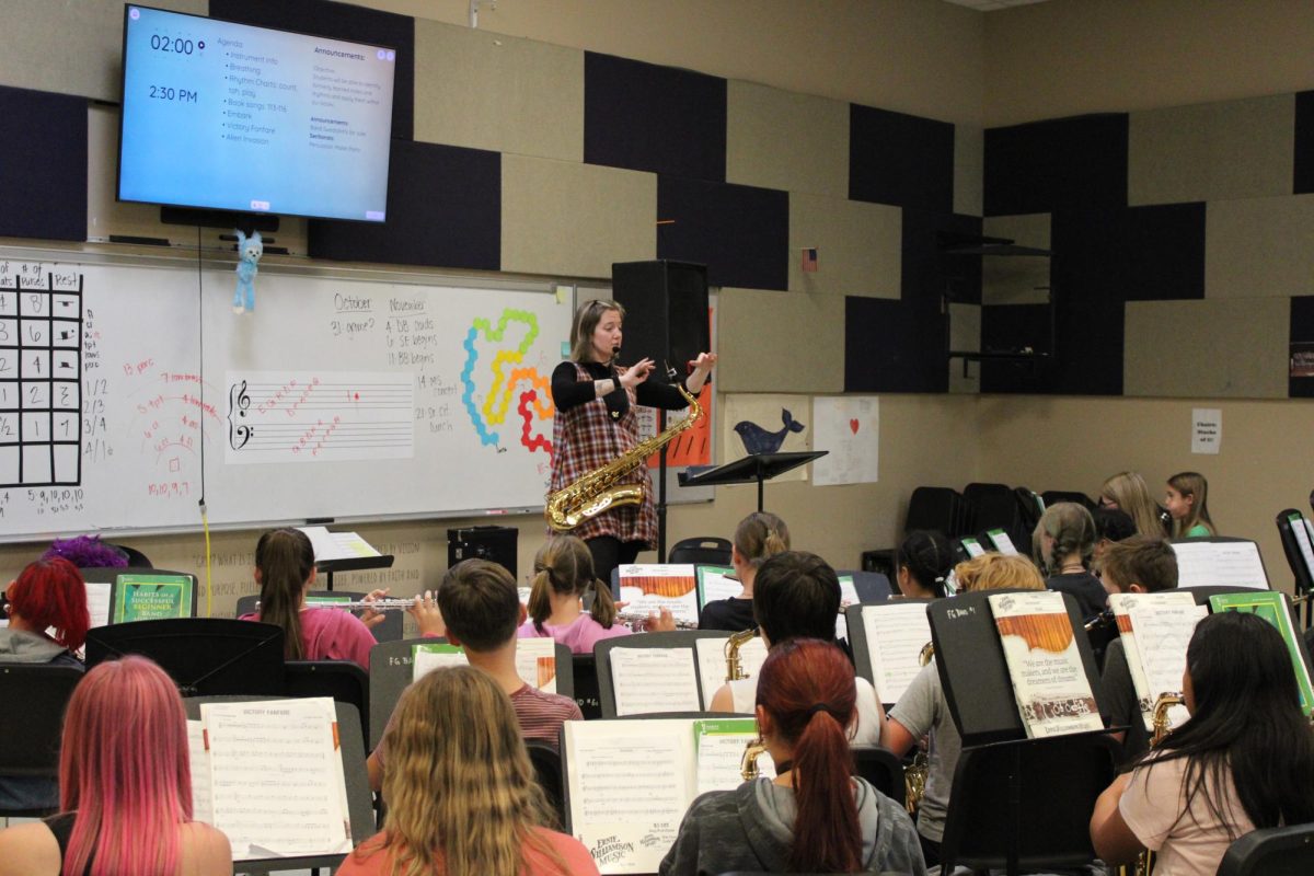 Band director Natalie Palomo conducting for the middle school band as they practice for their upcoming concert. Palomo's students are watching her so they can keep time.
