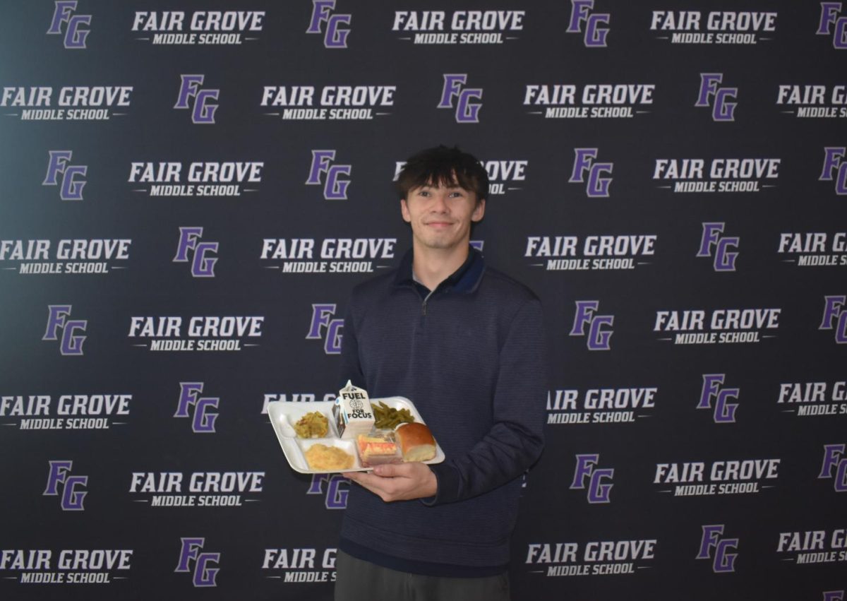 Macklen Johnson (12) showcases his Christmas meal, provided by the Fair Grove High School. His favorite dish is Hawaiian rolls.