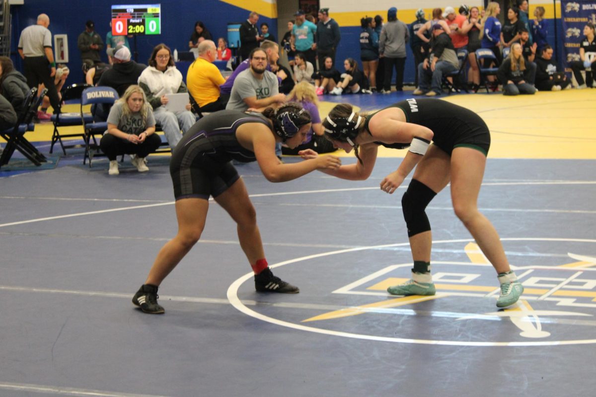 Brylee Mallard (left) preparing to face off against a Lady Warsaw Wildcat (right) in her first match of the season. They are both hand fighting to create angles for a take down. 