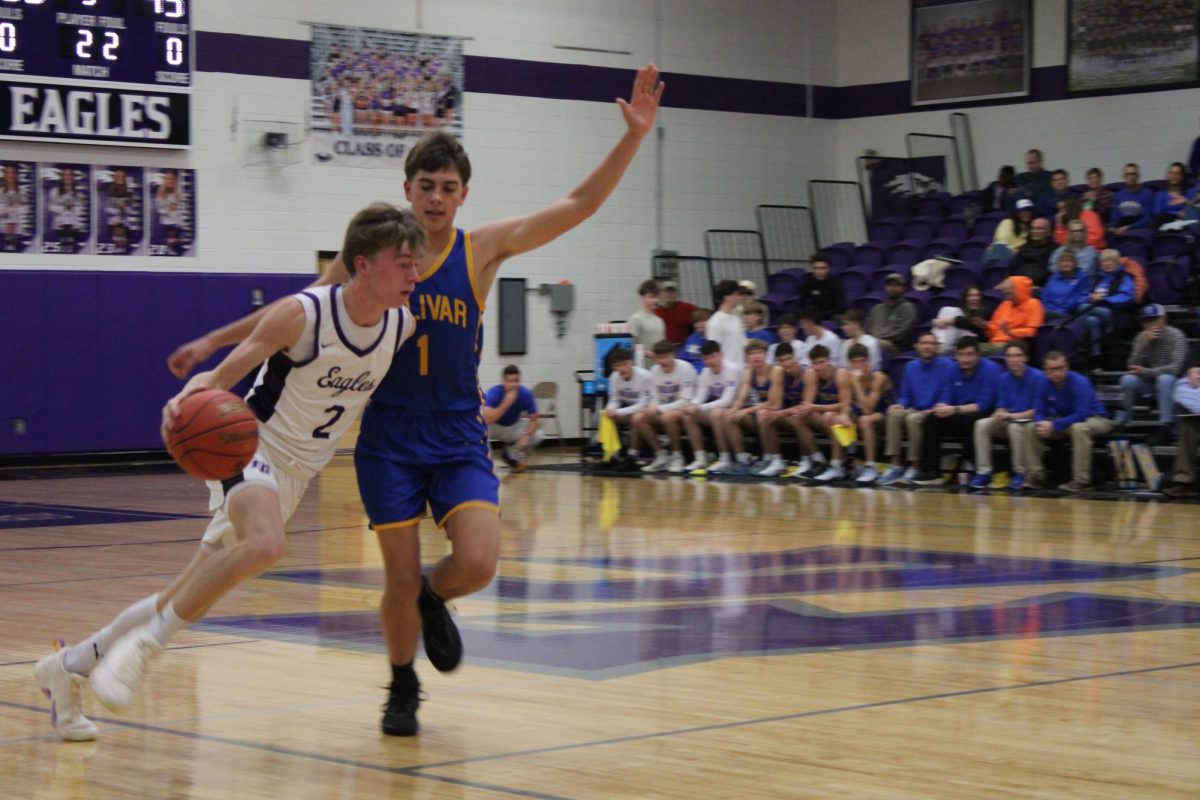 Grant Fuller (12) is dribbling the ball in transition in a game against Bolivar. Fuller states he hopes to compete in every game they play. 