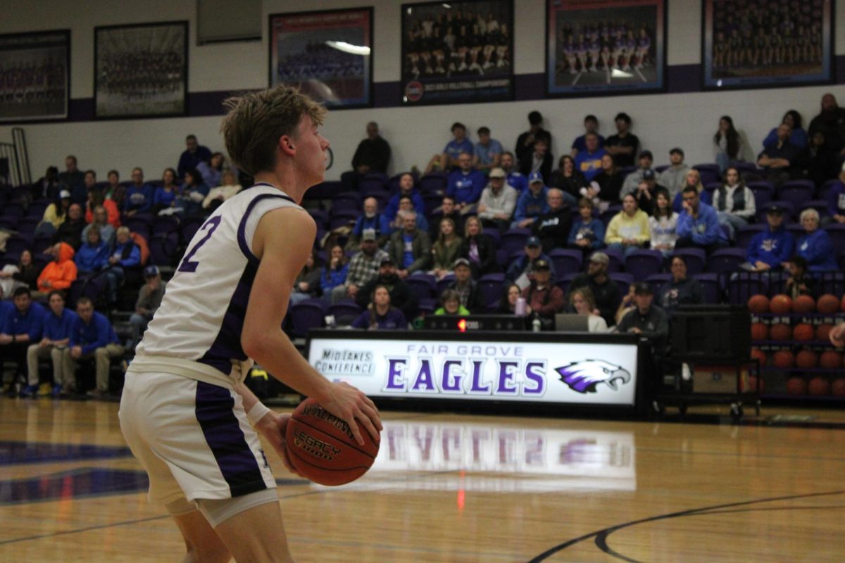 Grant Fuller (12) lining up to shoot a three-pointer against Bolivar at the 12/16 home game. Fuller scored nine of the team's 52 points. 