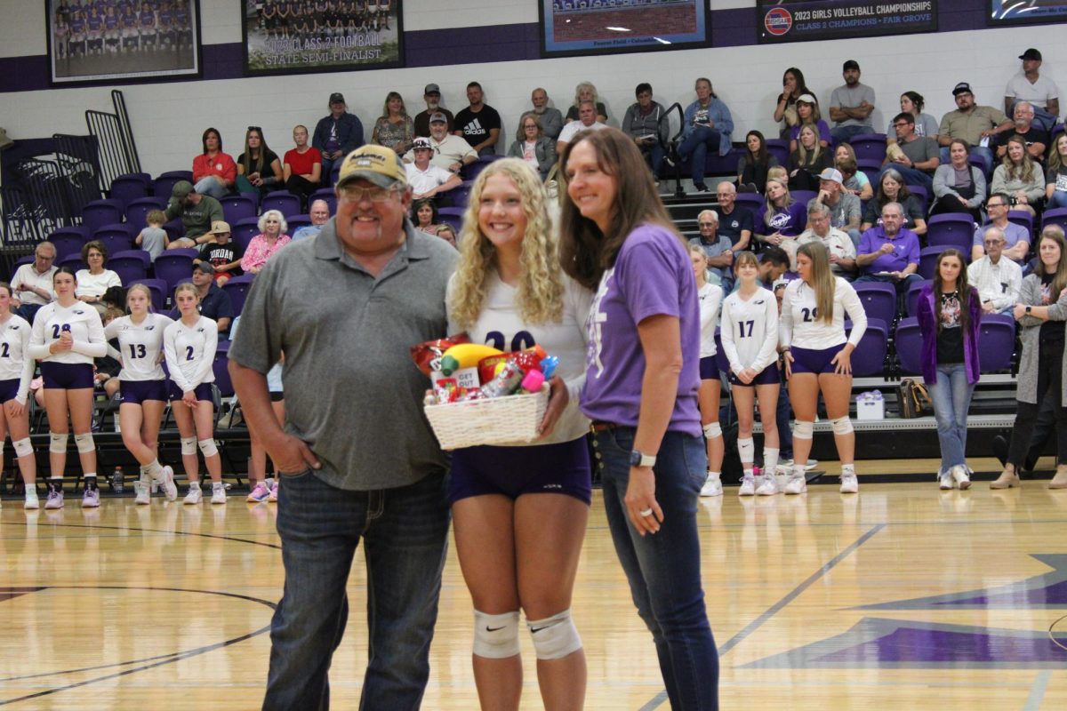 Sofee Garrett (12) posing with her parents Pat Garrett and Julie Garrett for her volleyball senior night photo. Fair Grove won this game 3-0 against the Forsyth Lady Panthers.
