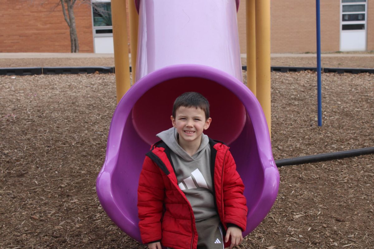 Kindergartener Ray Hart smiling after going down the slide during his second recess of the day. Recess is used as a time of play, to reset their minds for more learning.