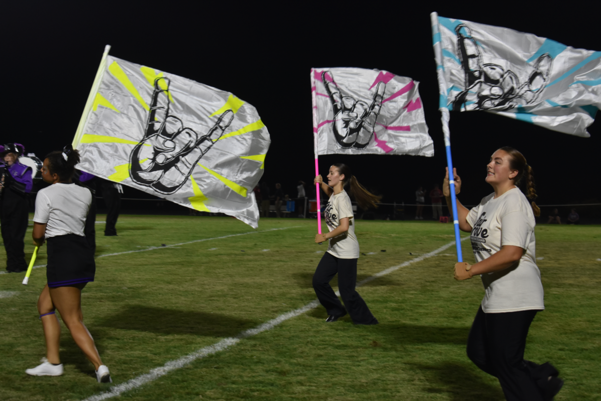 Left to right, Senior Eden Lair, with Sophomores Lacie Workman, and Megan Bright, performing their routine at a Fair Grove football game.