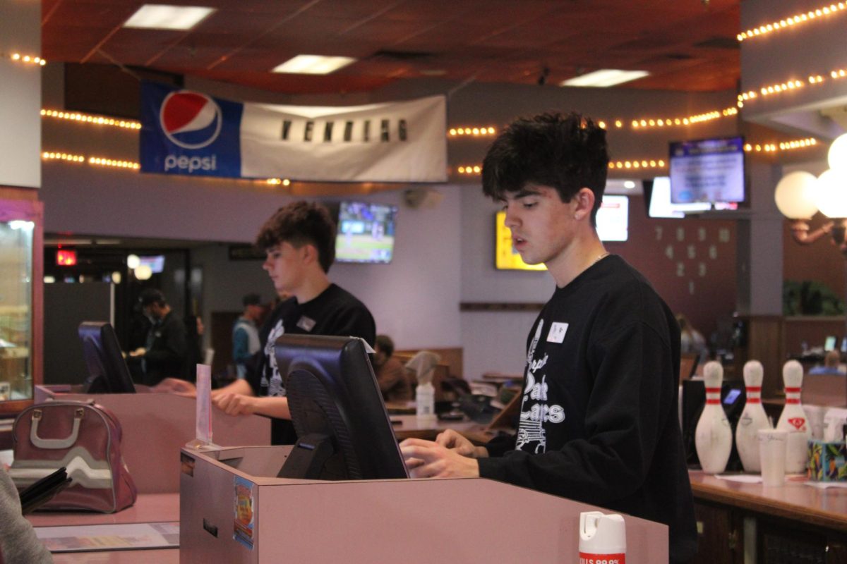 Eli Sanders (12) in the front and Jaiden Straw (12) in the back, selling customers bowling lanes and shoes for the night. This was taken during Rockin' Bowl, which is one of their busiest public events of the week.
