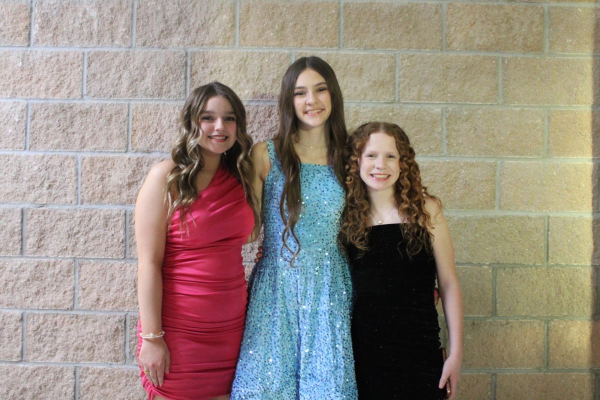 Middle school student council representatives Louella Gore (8), Karis Peck (8), and Addison Miller (8), at the middle school dance on February 13, 2026 in the middle school commons.