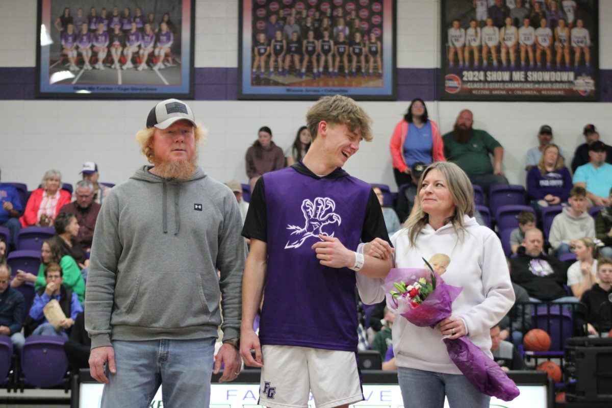 Grant Fuller (12) standing with his parents, Jason Fuller and Ashley Fuller, on senior night. The senior night game was played against Forsyth on 2/13.