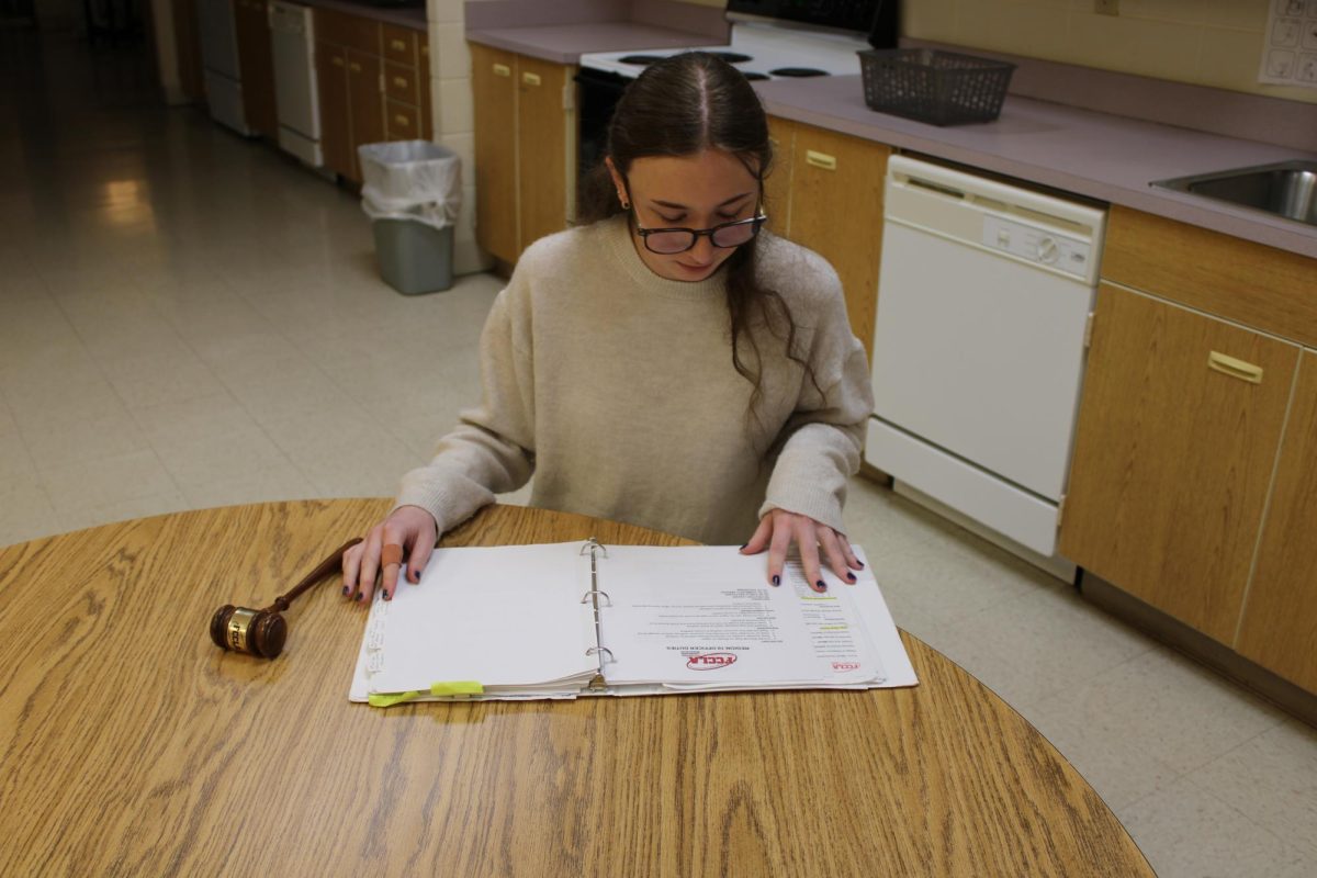 Madison Crews (11) reading information in her District President folder. This is preparing her to speak at the conference that will happen this month and will also inform her of all of the rules and regulations that she is taking on.