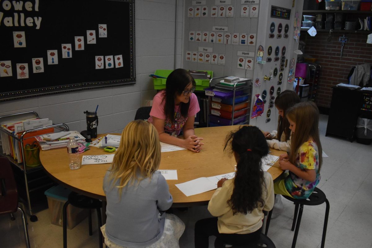 Kindergarten teacher Toni Robertson helping her students with homework. Students are working hard to finish up their work for the rest of the school year. 