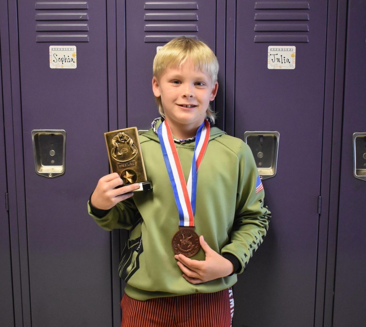 Rhett Manley (2), sporting his fifth place medal from Missouri USA State, and another one of his many trophies. Rhett competed in the Missouri USA State Championship on March 14, 2026. 