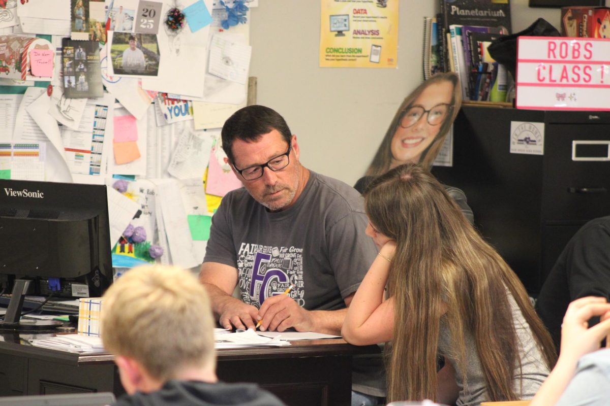 Matt Robertson (center) helping a student with an assignment.