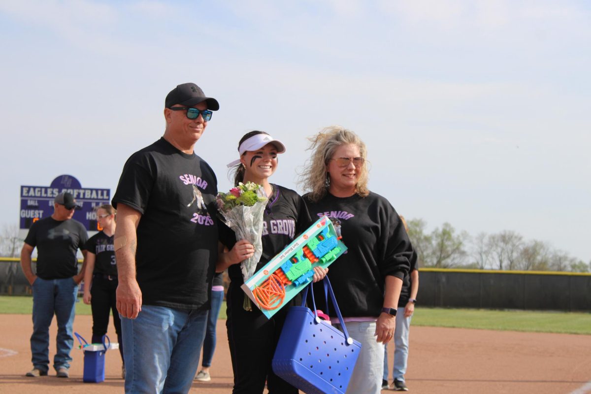 Addyson Nunley (12) stands with her parents on the softball senior night on 3/31.